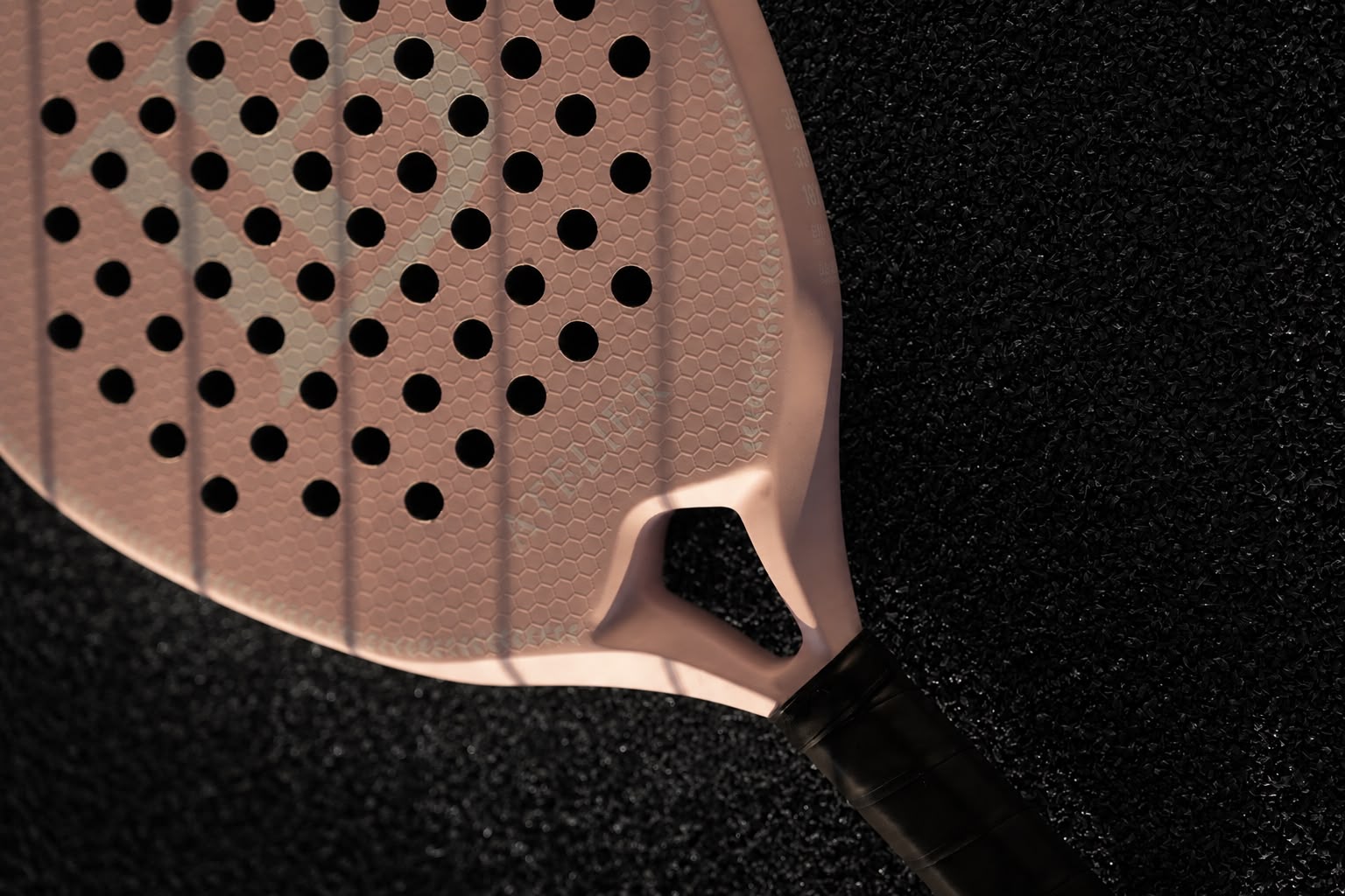Close-up of a blush pink LB Atelier racket face on black court surface