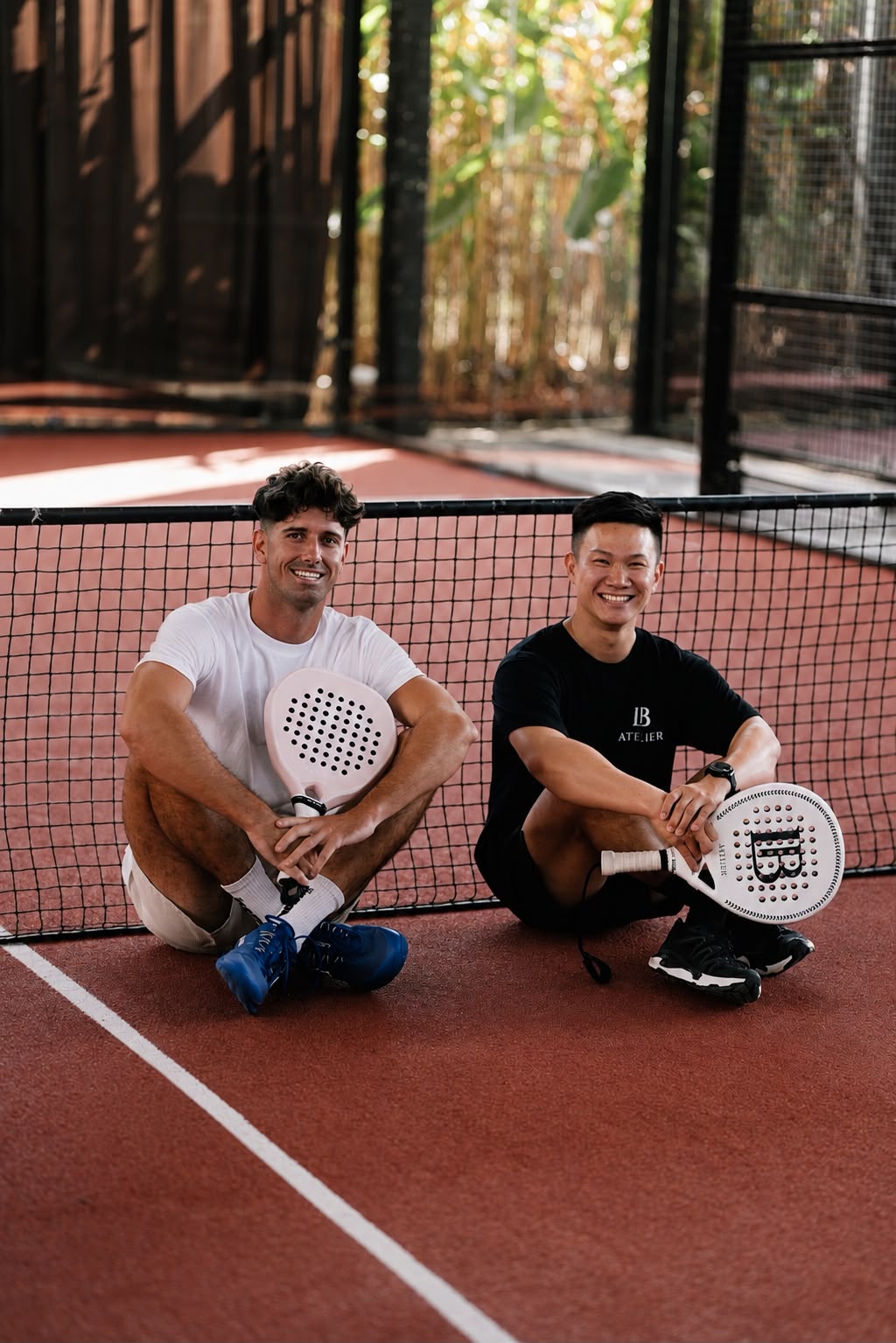 LB Atelier founders Liam and Bryan seated on a padel court
