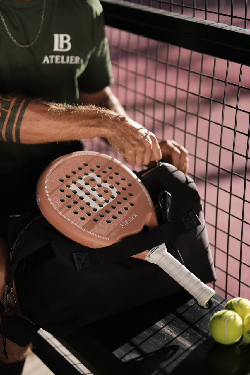 Terracotta LB Atelier racket resting on a court-side bag